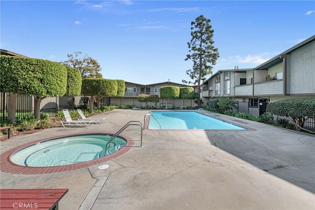 view of swimming pool featuring a hot tub and a patio