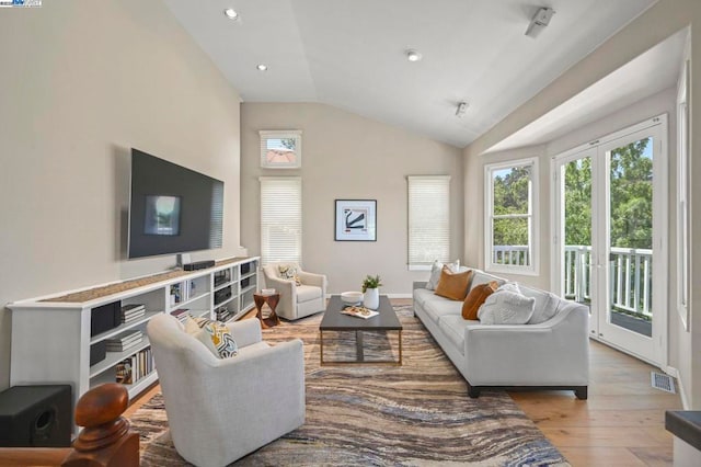 living room featuring vaulted ceiling and light hardwood / wood-style flooring