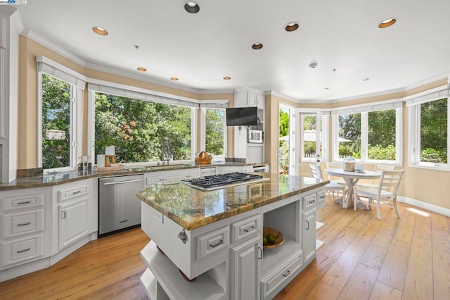 kitchen with white cabinetry, a center island, dark stone counters, and appliances with stainless steel finishes