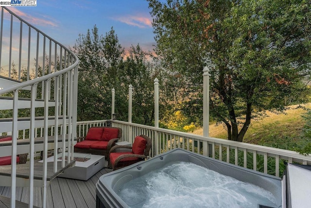 deck at dusk with an outdoor hot tub