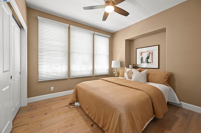 bedroom with ceiling fan, a closet, and light wood-type flooring