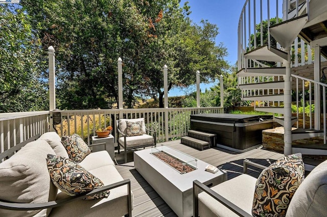 wooden terrace with a hot tub and an outdoor living space with a fire pit