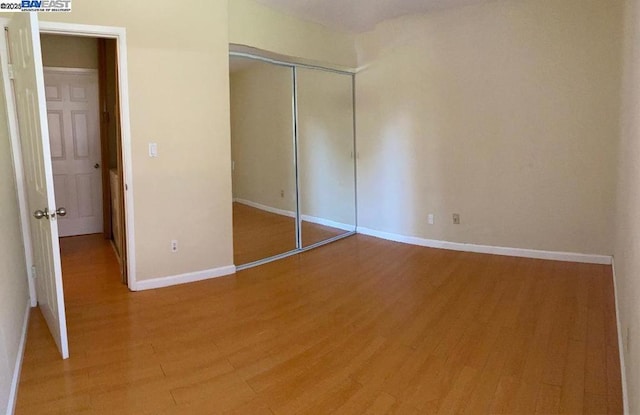 unfurnished bedroom featuring hardwood / wood-style flooring and a closet