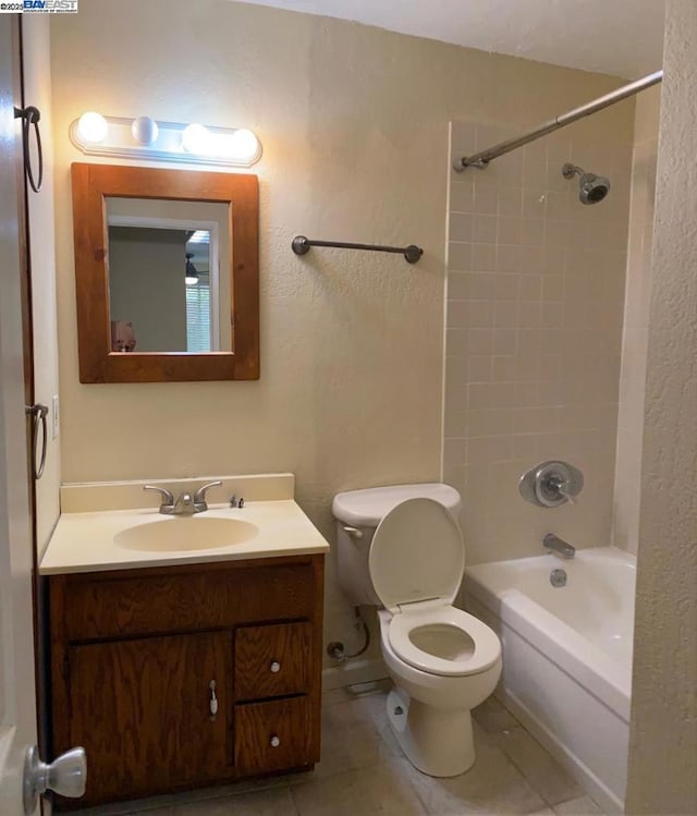 full bathroom with vanity, tiled shower / bath combo, tile patterned floors, and toilet