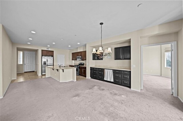 kitchen with decorative light fixtures, stainless steel appliances, recessed lighting, light colored carpet, and an inviting chandelier