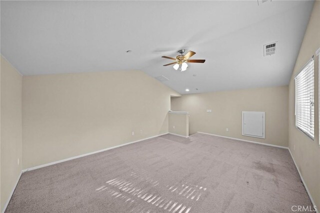 unfurnished room featuring visible vents, carpet flooring, vaulted ceiling, ceiling fan, and baseboards