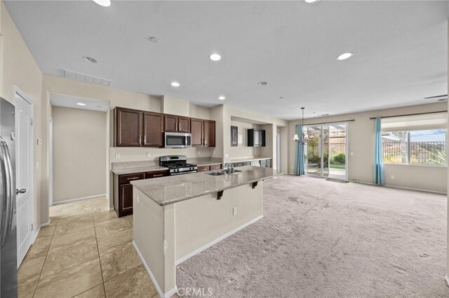 kitchen featuring stainless steel appliances, recessed lighting, visible vents, a kitchen island with sink, and dark brown cabinets