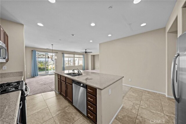 kitchen with recessed lighting, appliances with stainless steel finishes, open floor plan, a kitchen island with sink, and a sink