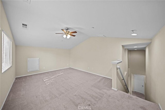 empty room featuring vaulted ceiling, carpet flooring, visible vents, and baseboards