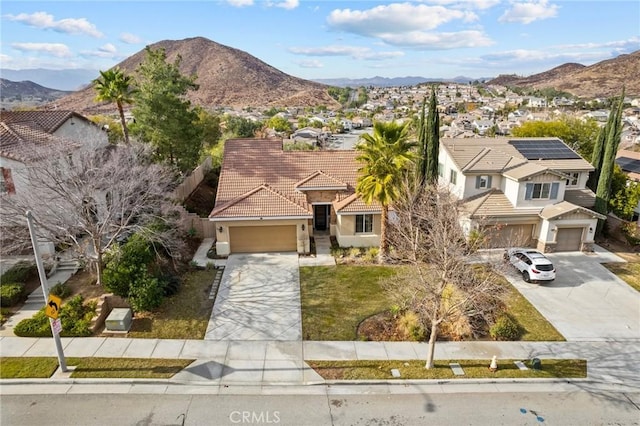 view of front of home featuring concrete driveway, a tile roof, a mountain view, and stucco siding