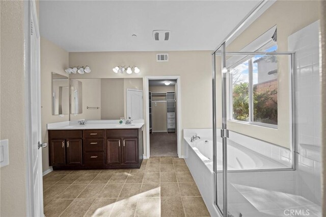 bathroom with double vanity, a garden tub, a shower stall, and a sink