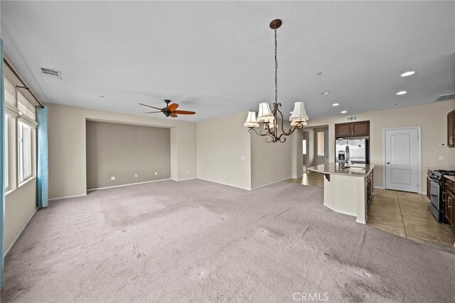 unfurnished living room featuring recessed lighting, a sink, visible vents, and light colored carpet