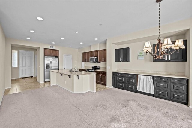 kitchen featuring light carpet, appliances with stainless steel finishes, a kitchen breakfast bar, and recessed lighting