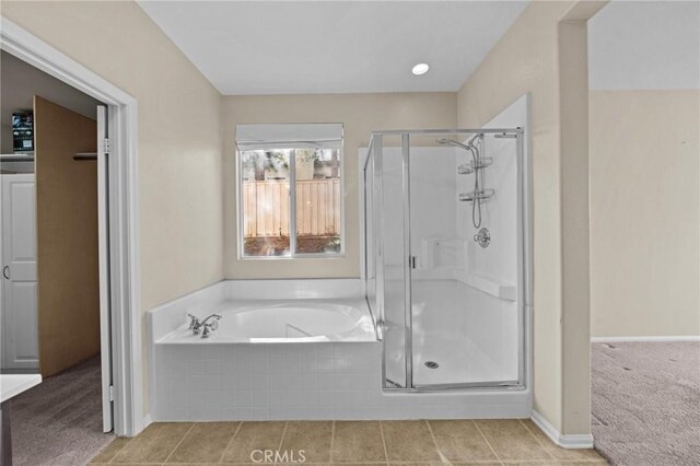 full bath featuring a stall shower, baseboards, and a garden tub