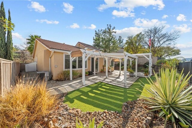 rear view of property featuring a patio area, stucco siding, a fenced backyard, and a pergola