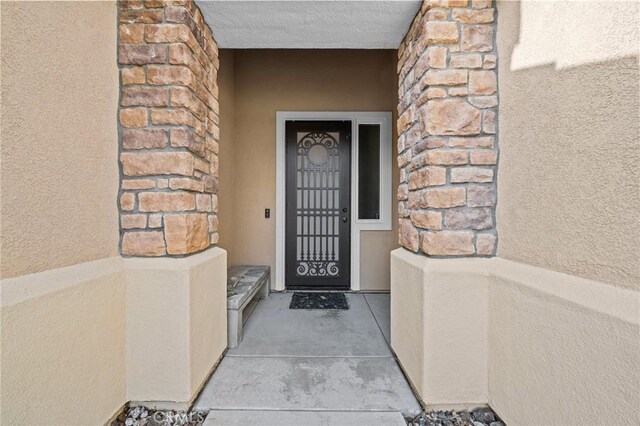 view of exterior entry featuring stucco siding