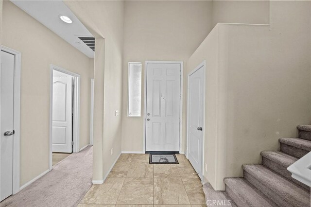 foyer with visible vents, baseboards, and stairs