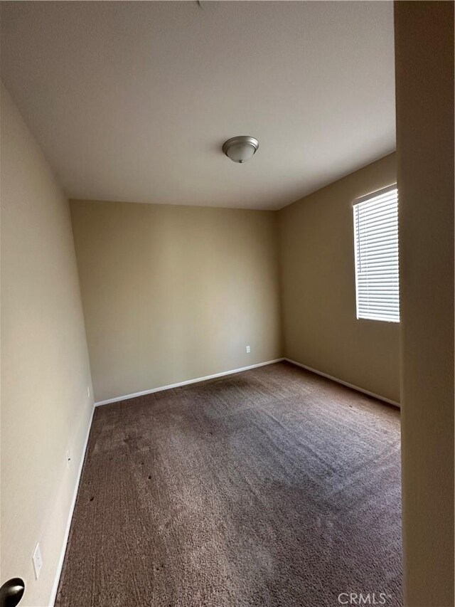 carpeted empty room with baseboards