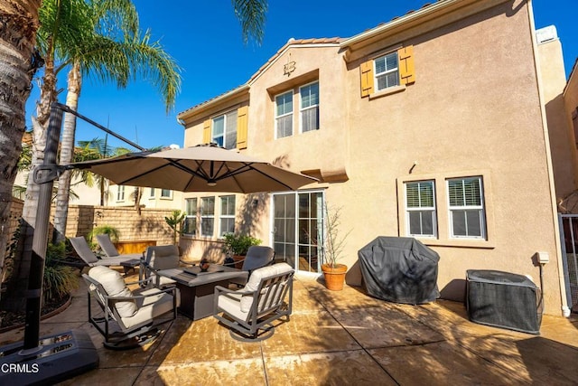 rear view of property with a patio area and an outdoor fire pit