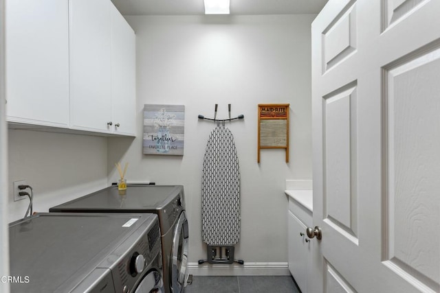 laundry area featuring cabinets, washer and dryer, and dark tile patterned floors