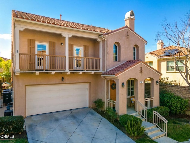 mediterranean / spanish-style house featuring a garage, a balcony, and covered porch