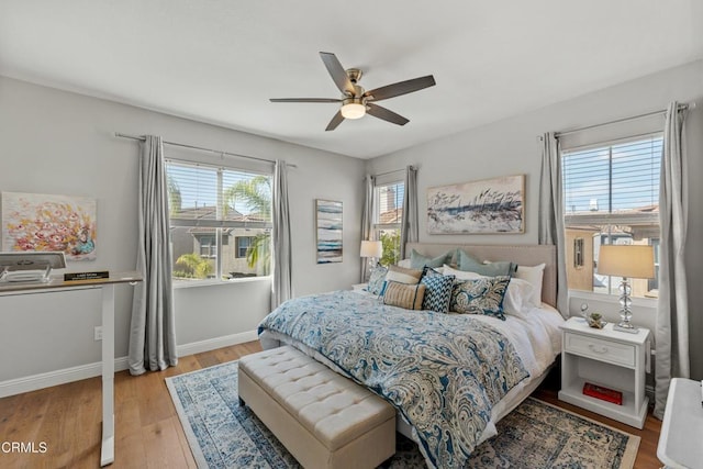 bedroom with multiple windows, ceiling fan, and light hardwood / wood-style flooring