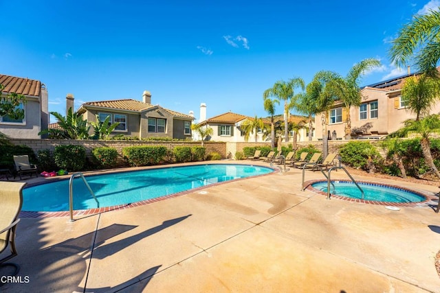 view of swimming pool featuring a community hot tub and a patio area