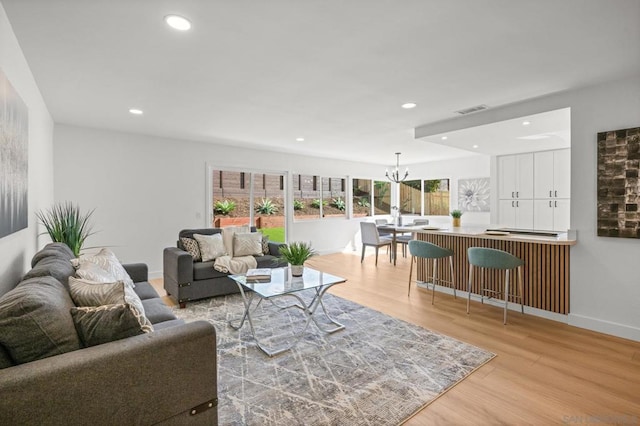 living room with an inviting chandelier and light hardwood / wood-style floors