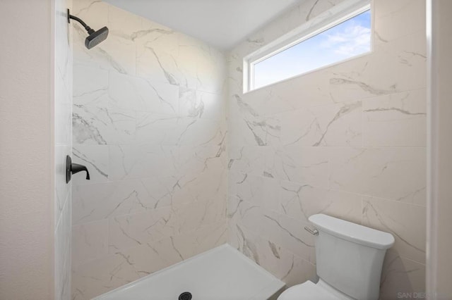 bathroom featuring toilet and a tile shower