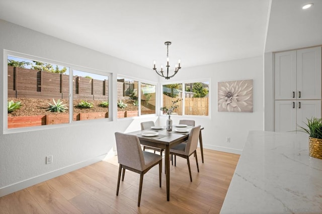 dining area featuring an inviting chandelier and light hardwood / wood-style flooring