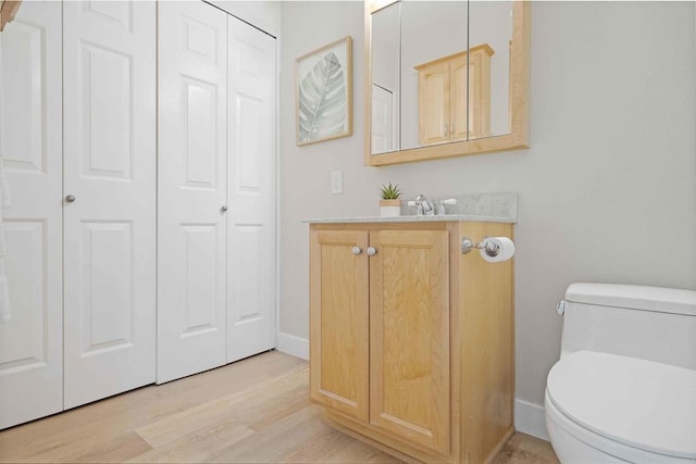 bathroom featuring vanity, hardwood / wood-style flooring, and toilet