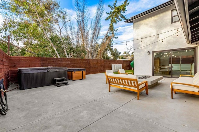 view of patio / terrace featuring a hot tub and a fire pit