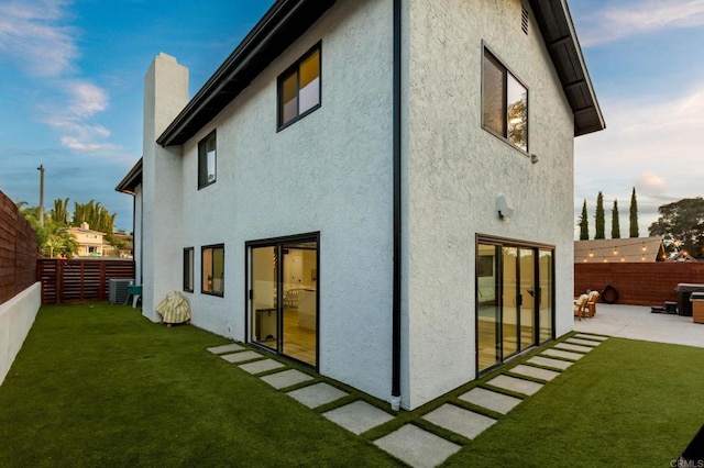 rear view of house with a yard, a patio, and central air condition unit