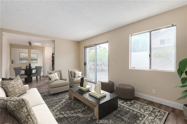 living room featuring dark wood-type flooring and a textured ceiling