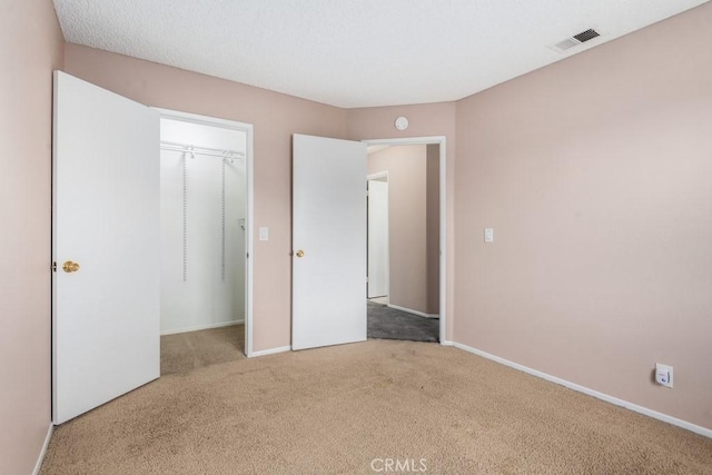 unfurnished bedroom featuring light colored carpet and a closet