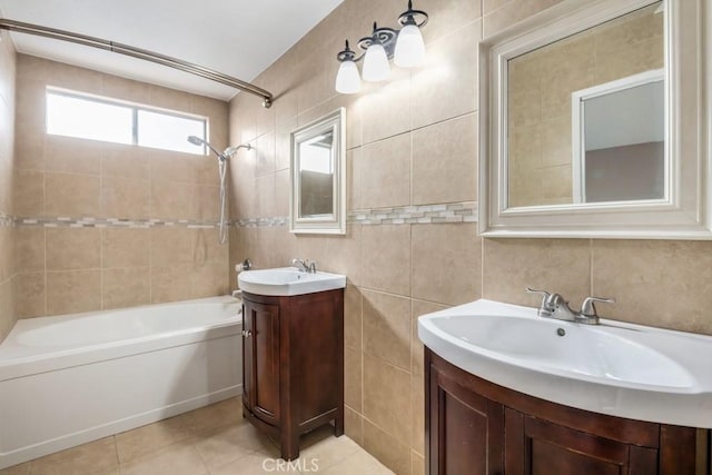 bathroom featuring tile patterned flooring, tiled shower / bath, tile walls, and vanity