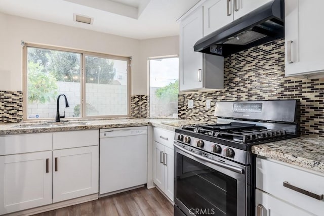 kitchen with stainless steel gas stove, white cabinetry, sink, exhaust hood, and white dishwasher