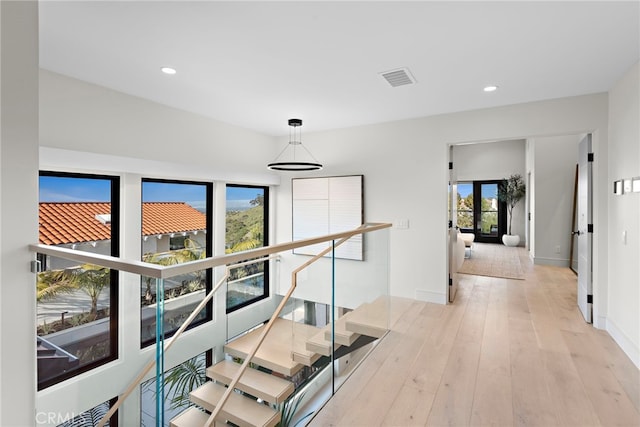 corridor with a healthy amount of sunlight and light hardwood / wood-style flooring