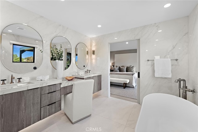 bathroom featuring tile walls, vanity, and a bath