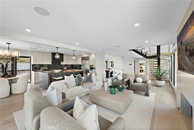 living room with light wood-type flooring and a chandelier