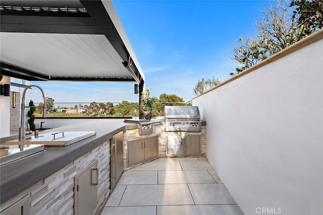 view of patio / terrace featuring exterior kitchen, a grill, and sink