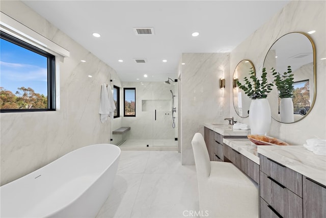 bathroom featuring a wealth of natural light, tile walls, independent shower and bath, and vanity