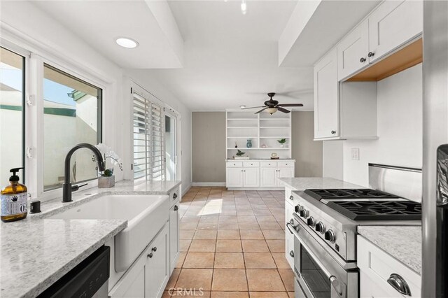 kitchen with stainless steel appliances, light stone countertops, sink, and white cabinets