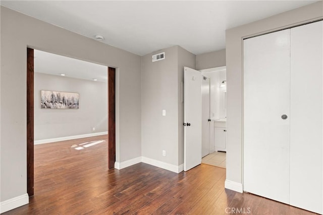 unfurnished bedroom featuring hardwood / wood-style flooring and a closet