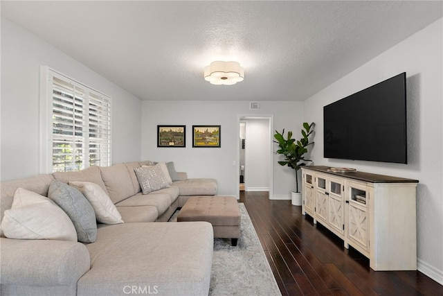 living room featuring dark hardwood / wood-style floors and a textured ceiling