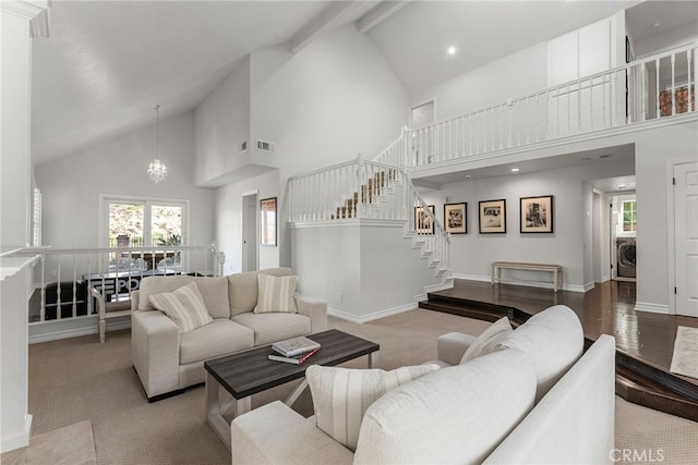 living room featuring a wealth of natural light, high vaulted ceiling, a chandelier, and beamed ceiling