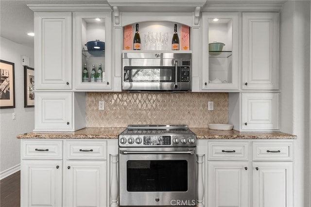 kitchen with white cabinetry, dark stone counters, and appliances with stainless steel finishes