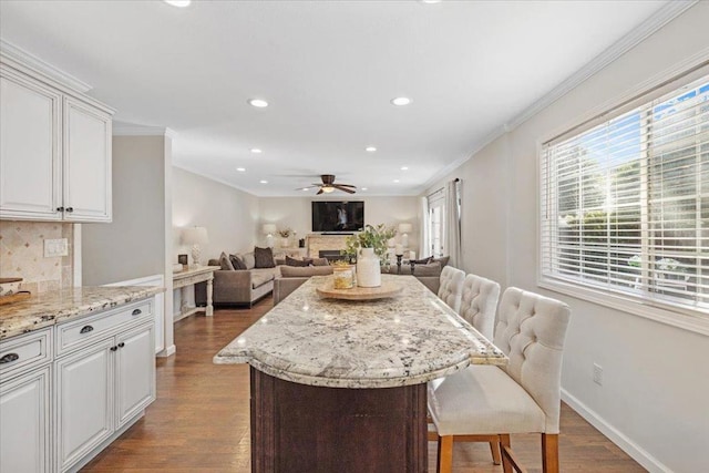 dining space with crown molding, ceiling fan, and dark hardwood / wood-style flooring