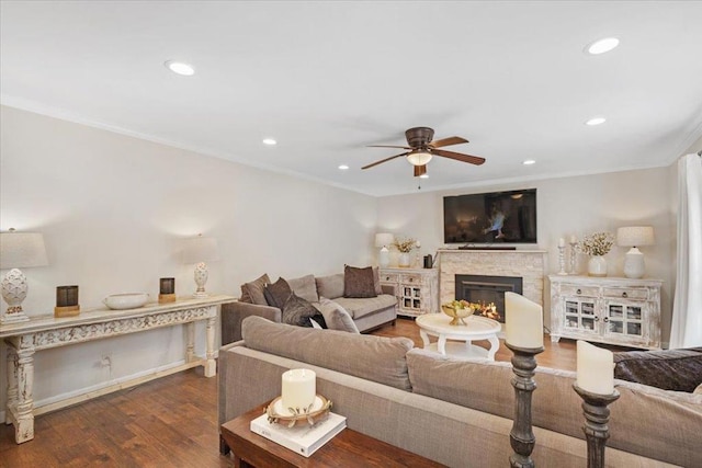 living room with dark wood-type flooring, ceiling fan, and ornamental molding