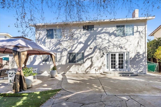 rear view of property featuring a patio, a gazebo, and french doors